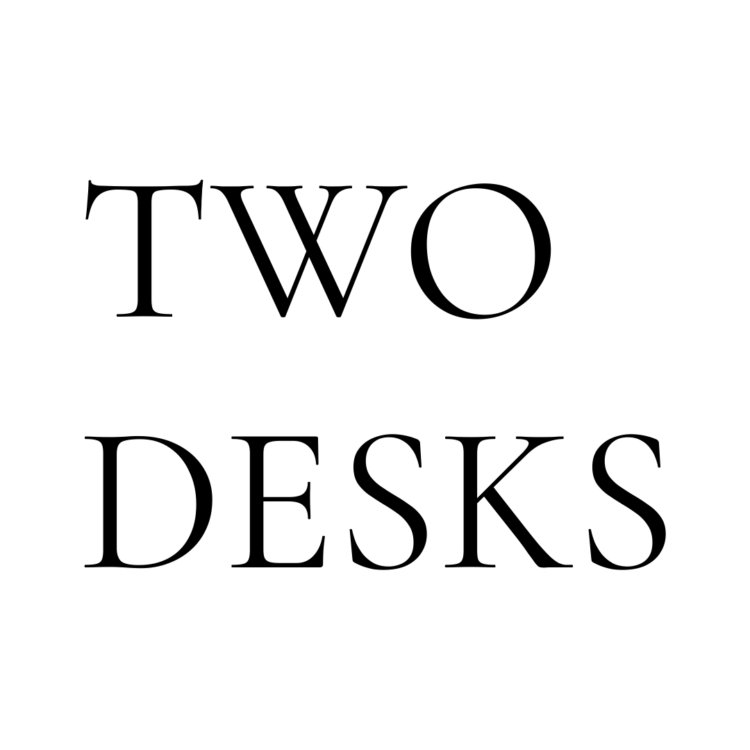 The words "TWO DESKS" are displayed in black serif font against a white background.